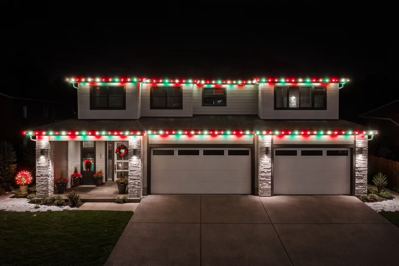 Red, green and white lights along both stories of a home at night