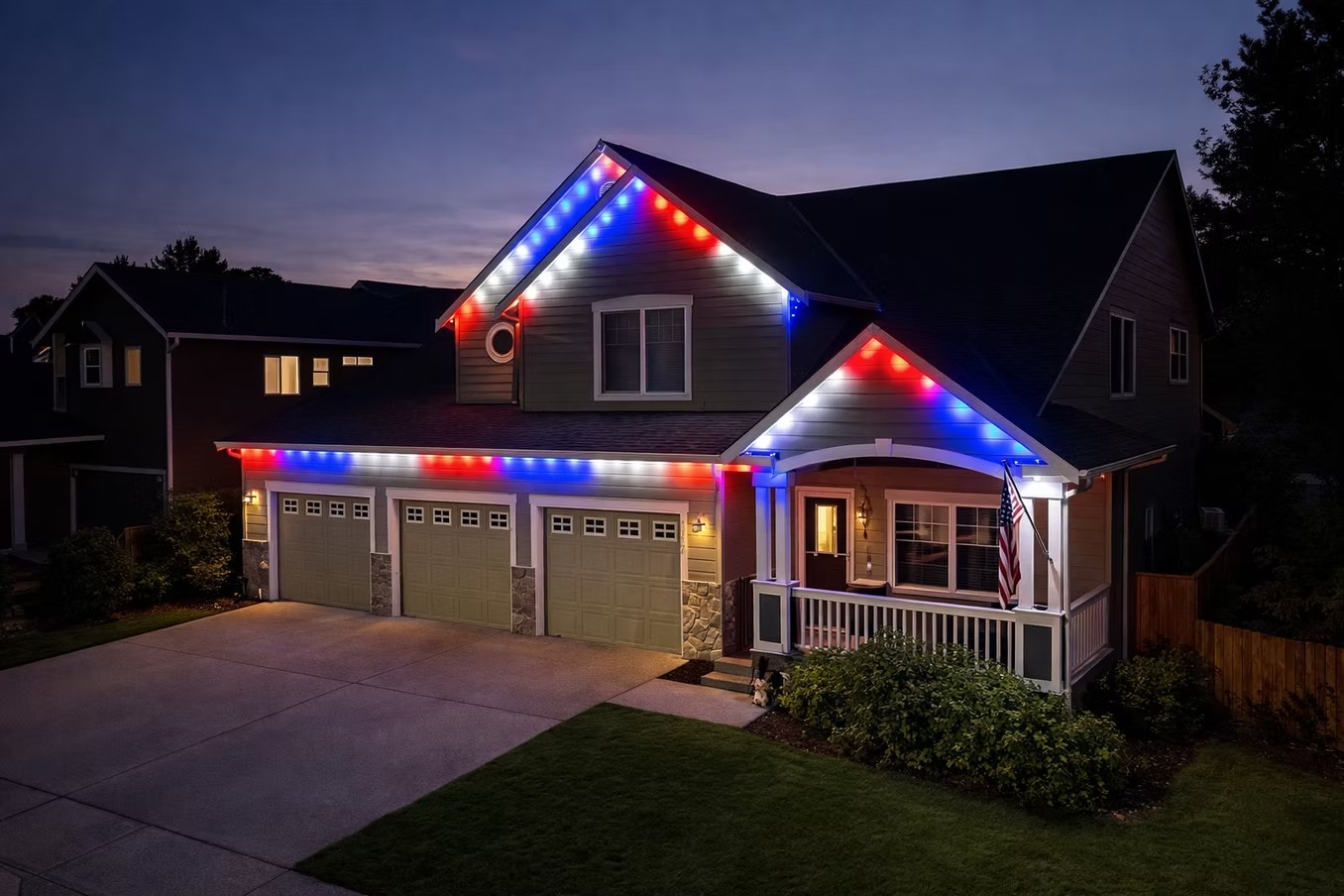 Red, white and blue lighting along a two-story home’s roofline at dusk