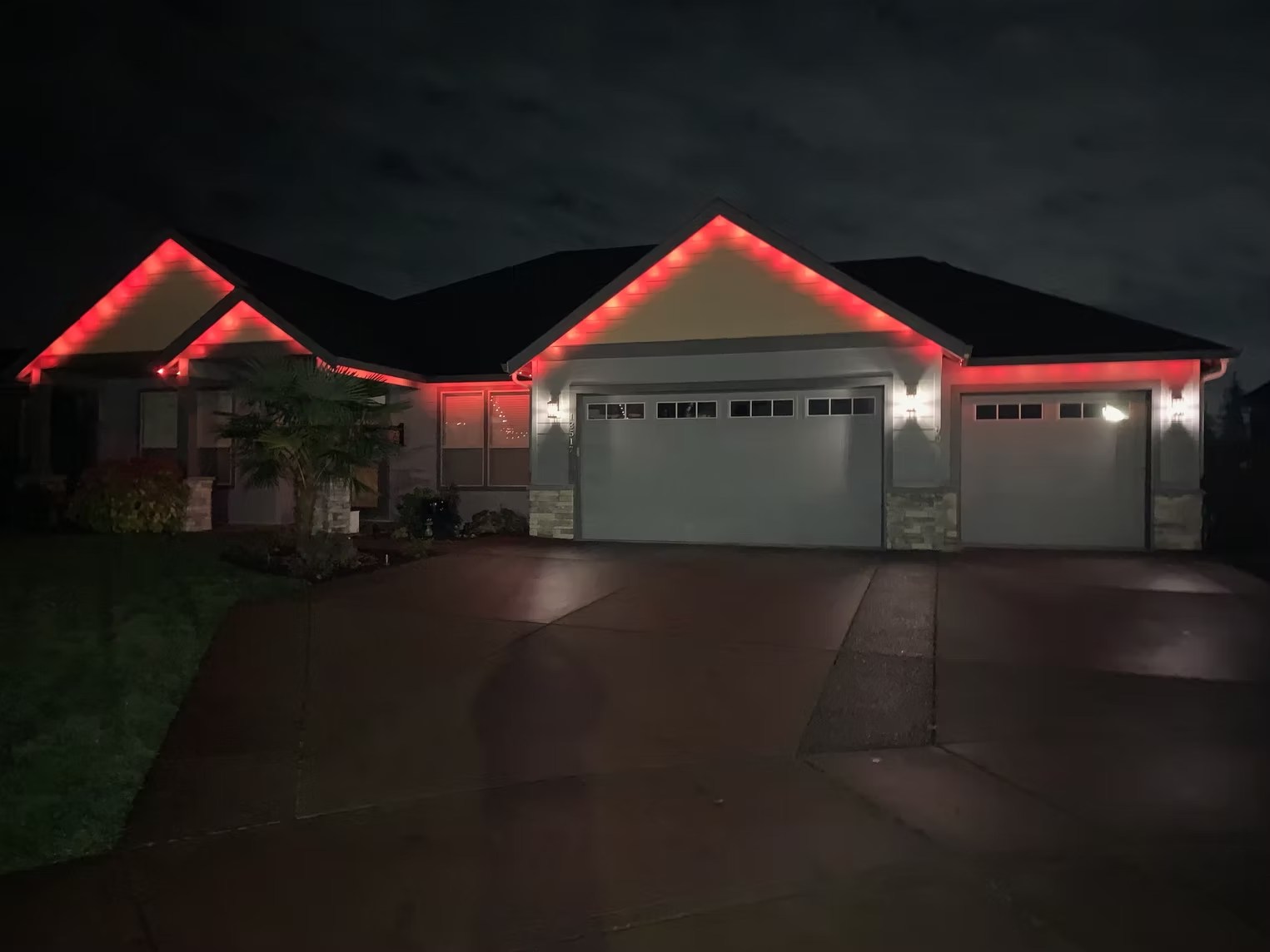 Red roofline lighting on a single-story home under an evening sky